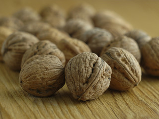  walnuts laid out on a wooden board on a washed background