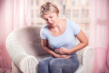 Obraz premium Woman feels strong stomach pain. People, healthcare and medicine concept