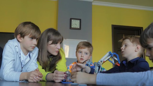 Kids creating figures with teacher. Early development, modern technology concept