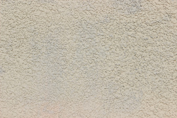 Texture of a wall made of crushed stone plastered with cement painted in gray