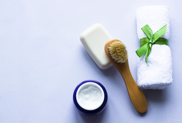 Wooden soft massage brush for body, soap, cream, towel with ribbon on white background, copy space. Skin care products. Massage brush with natural bristles for body peeling or anti-cellulite massage. 