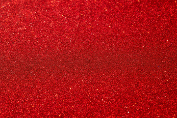 Festive abstract red glitter texture background. Colorful background with glittering and sparkling spots. Suitable for christmas, new year, chinese new year and designs. Selective focus