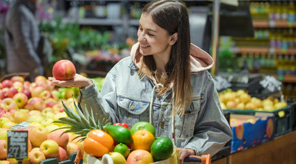 A young woman buys groceries in a supermarket.