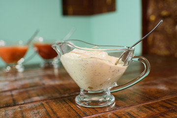 Adjika, garlic and barbecue sauces on a large wooden table