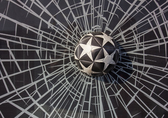 black and white soccer ball with stars in broken glass