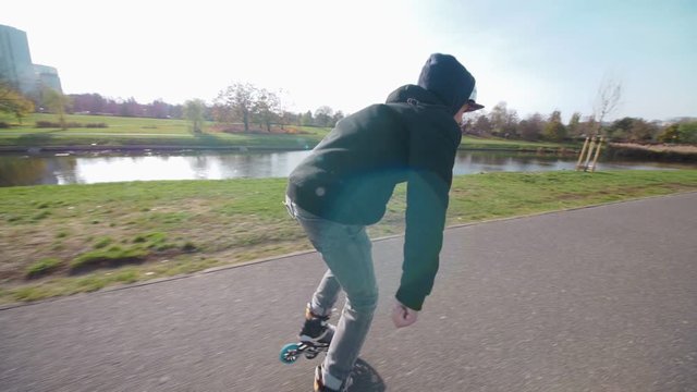 Fast Fitness skating near pond in slow motion