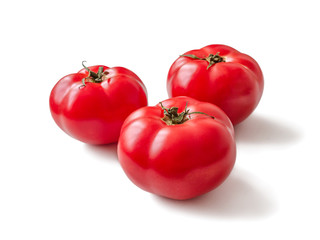Ripe red tomatoes with green cuttings on a white background