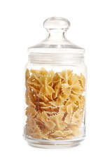 Raw pasta in a glass jar isolated on a white background.
