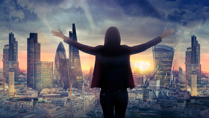 Young woman looking over the City of London at sunset. Beautiful city background in gentle light....