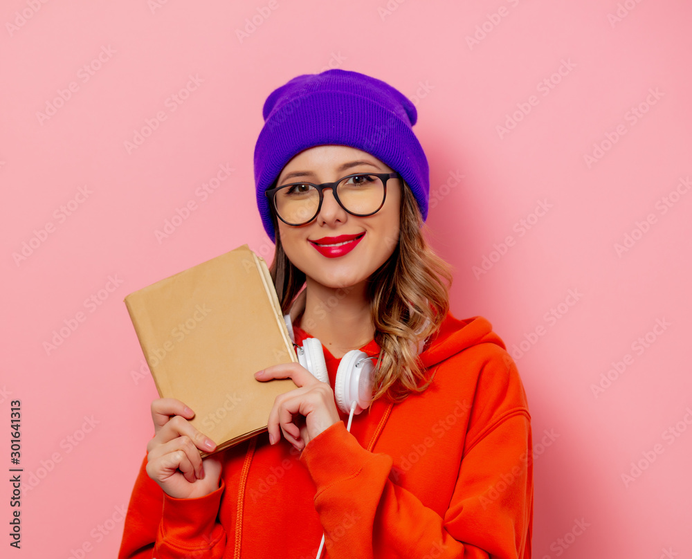 Wall mural style woman with headphones and books on pink background