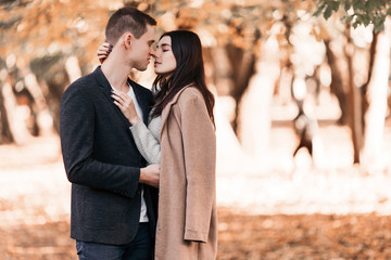 Beautiful young couple walking in autumn park.