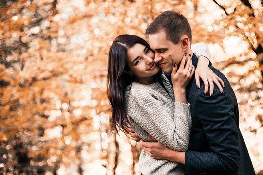 Beautiful young couple walking in autumn park.
