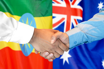 Handshake on Ethiopia and Australia flag background.