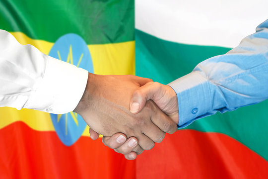 Handshake on Ethiopia and Bulgaria flag background.