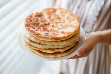 Homemade Khachapuri in hands of a young housewife. Fresh, tasty Georgian bread just after baking in hands of young girl