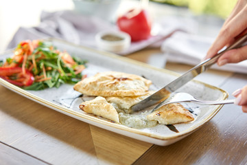 Woman eats Latin American fried empanadas with Vegetable salad with arugula. Decorated with balsamic sauce. Menu restaurant