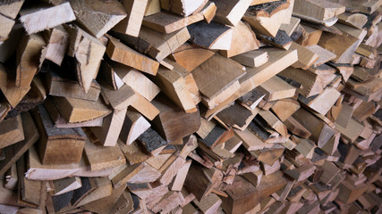  Background of dry chopped firewood logs in a pile. Harvesting firewood for the winter.