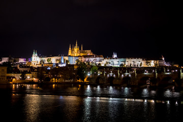 Illuminated Saint Vitus Cathedral, Hradcany Castle And River Moldova In The Night In Prague In The Czech Republic