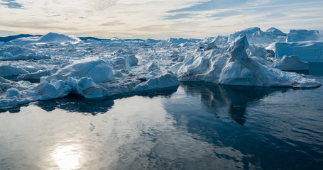 Drone photo of Iceberg and ice from glacier in arctic nature landscape on Greenland. Aerial photo drone photo of icebergs in Ilulissat icefjord. Affected by climate change and global warming. - obrazy, fototapety, plakaty
