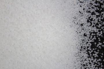 surface made of white plastic granules with black granules mixed with them.