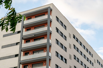 Angular view on high-rising modern building of apartments with balconies.