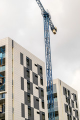 Fototapeta na wymiar Construction crane and new modern buildings of apartments.