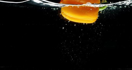 Yellow pepper falls into water isolated, slow motion, shot on Red Weapon Helium, bubbles in water, splashes, Laowa Probe Macro 24mm lens - Powered by Adobe