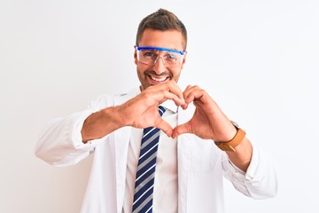 Young handsome scientist man wearing safety glasses over isolated background smiling in love showing heart symbol and shape with hands. Romantic concept.