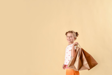 black friday sale.fashionable child in trendy suit jumping with craft package, big purchases not a bright yellow background. black friday banner concept.