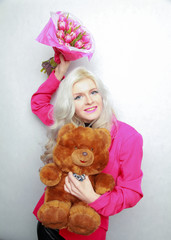 tender pretty blonde slim teen girl with pink flowers. cheerful woman with fresh bouquet