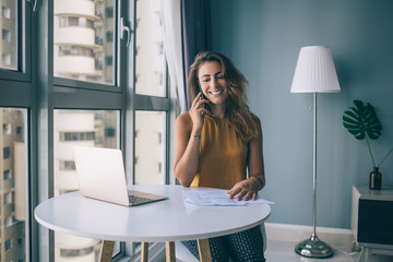 Caucasian female with cute smile on face spending time for checking information about family budget...