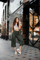 Fototapeta premium Beautiful smiling woman drink coffee walking on the city in summer day.