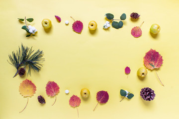 Autumn rectangle layout with forest nature elements - wooden pine cones, leaves, berries on yellow background.