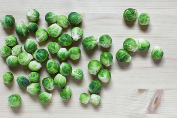 Many green brussel cabbages on wooden background arrange freely randomly.
