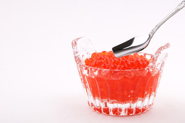 spoon over a crystal dish with red caviar