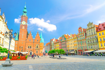 Fototapeta na wymiar Old Town Hall building, row of colorful buildings with multicolored facade and street lamp on cobblestone Rynek Market Square in old town historical city centre of Wroclaw, Poland