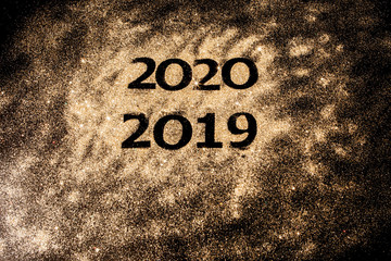 Fototapeta na wymiar Beautiful sparkling Golden Numbers of 2019 to 2020 on black background for design, happy new year concept