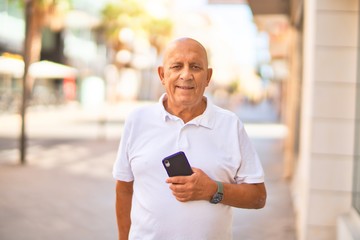 Senior handsome man smiling happy and confident. Standing with smile on face using smartphone at town street