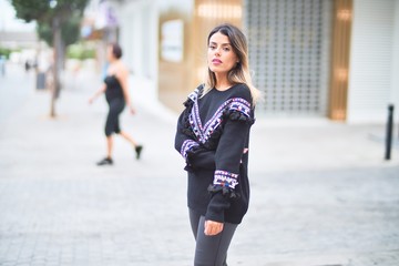 Young beautiful girl wearing sweater walking at street town