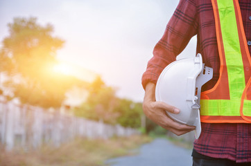 White safety helmet is in the hands of an electrician.