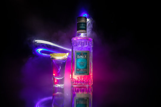 Baku, Azerbaijan - JUNE 16. 2019. Olmeca Tequila on wooden table on a dark toned foggy background. Olmeca Tequila is a tequila produced in Jalisco, Mexico.