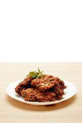 Deep fried fish paste balls served on white plate set on wooden