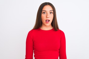 Young beautiful girl wearing red casual t-shirt standing over isolated white background afraid and shocked with surprise expression, fear and excited face.