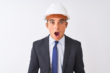 Young handsome architect man wearing suit and helmet over isolated white background afraid and shocked with surprise expression, fear and excited face.
