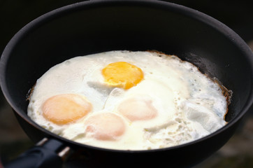Fried eggs in a black pan as the fastest and easiest breakfast