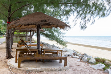 empty chairs and wooden umbrellas on a sandy beach