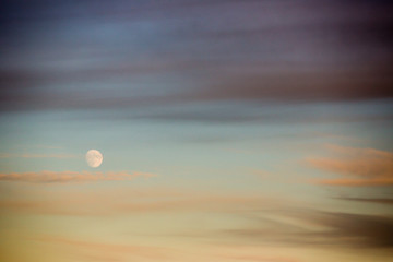 waning moon cloud streaked evening sky