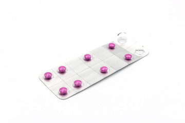 Packing of pink tablets on white isolated background.