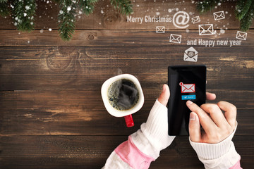 Hand of female using mobile phone to sending E-mail message with email symbol and envelope icon. Christmas and New Year holiday greetings email concept. - obrazy, fototapety, plakaty