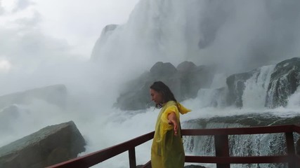 Traveler enjoys waterfall in Cave of the Winds under the Niagara Falls, watered down by waterfall, incredible emotions, travel around the United States